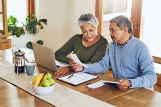 Couple sitting at table with laptop